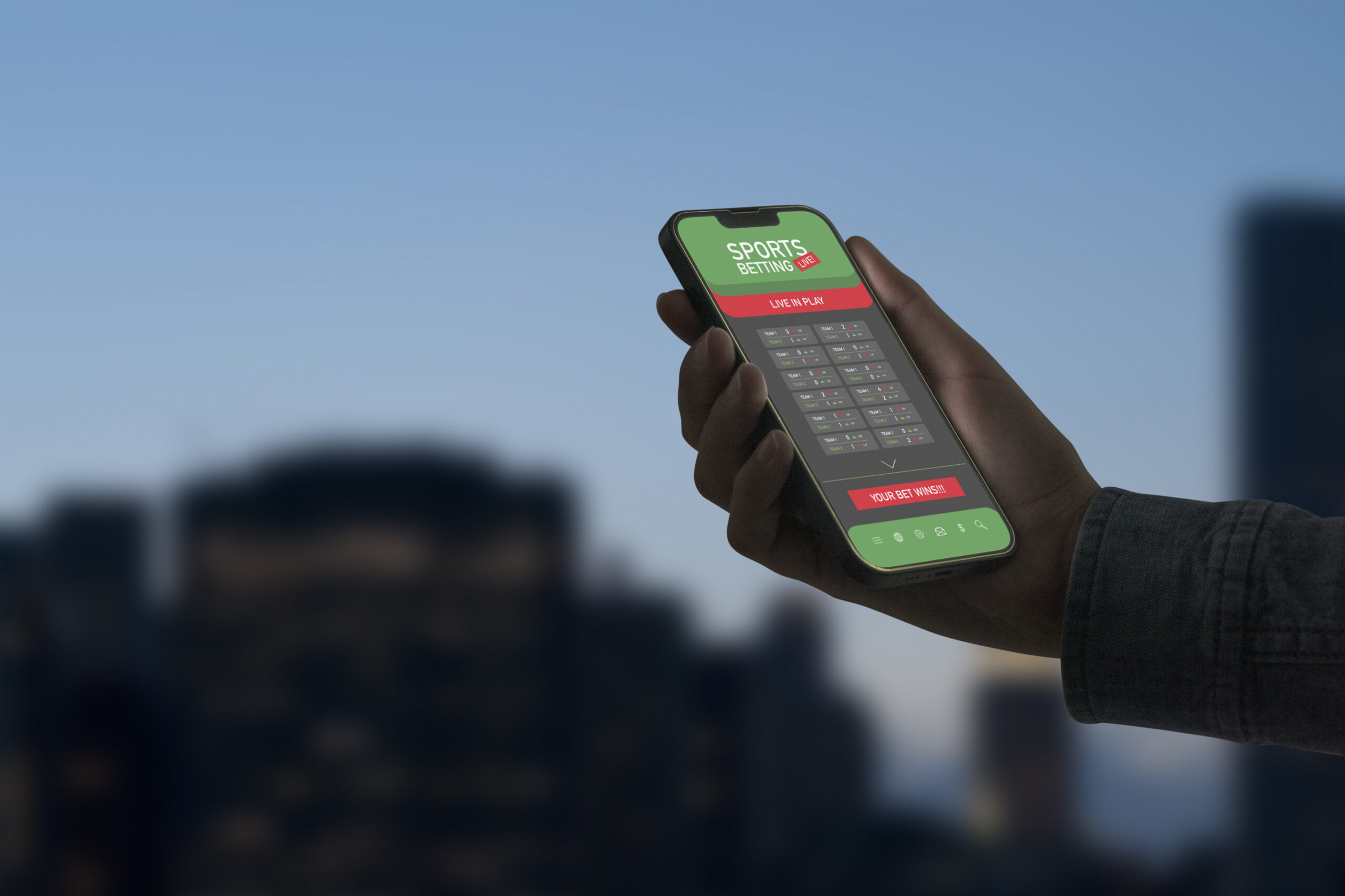 Live in-play betting app on smartphone display, user holding a smartphone and checking scores
