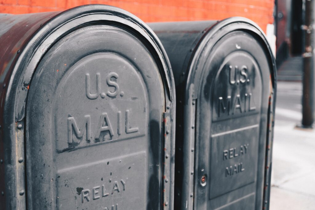 Close view of two gray U.S. postal service mailboxes.